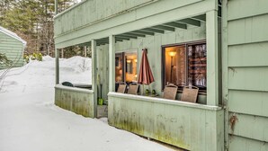 Un bâtiment en bois doté d’un porche abrité, d’un banc et d’une table.