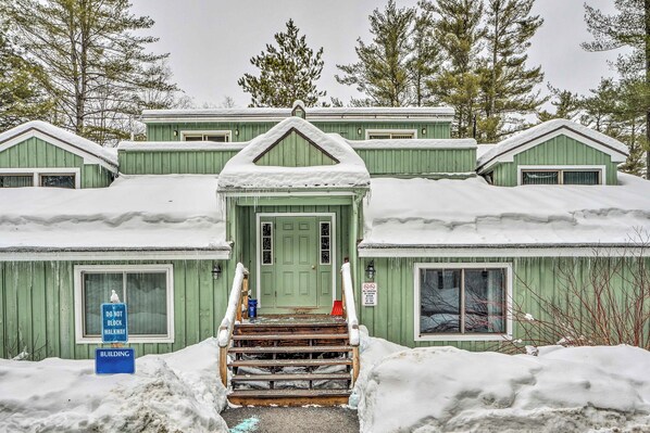 A green building with a snow-covered entrance and steps leading up to the door. - Bartlett Condo ~ 1 Mi to Attitash Resort! (Bartlett)