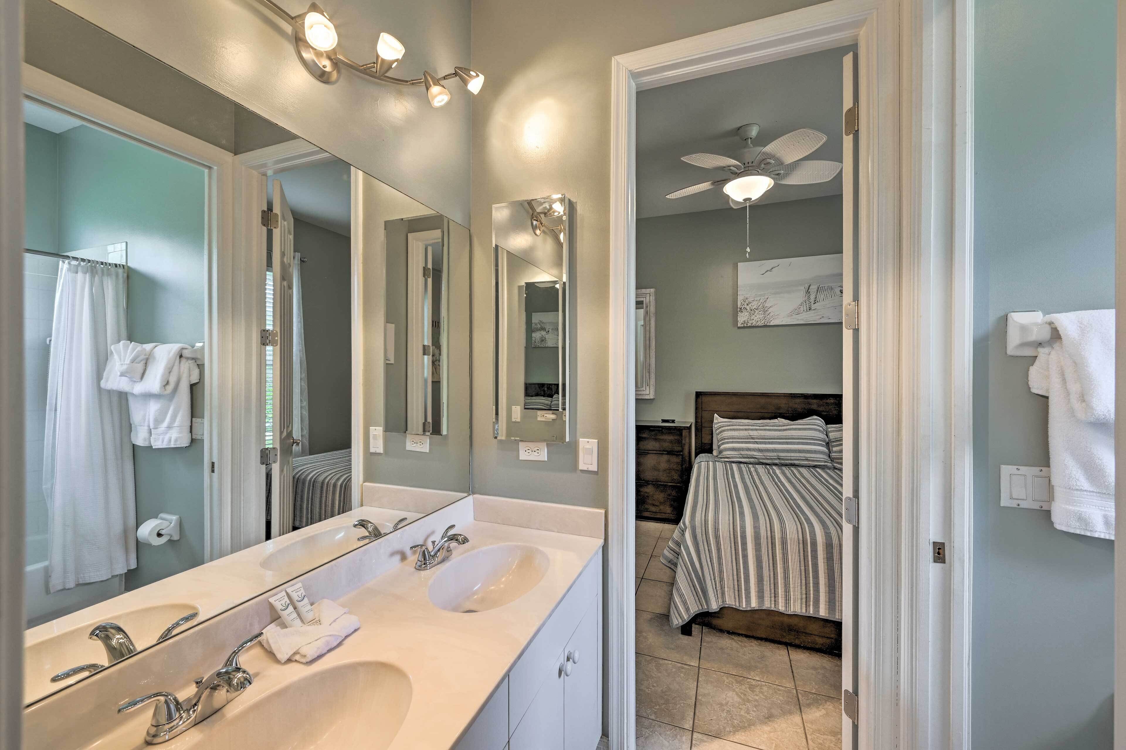 Un bagno con doppio lavabo, uno specchio grande e una ventola a soffitto.