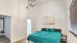 A bedroom with a bed, a nightstand, a wall-mounted artwork, and a window with blinds. - Rural Gilmer House w/ Covered Patio! (Gilmer)
