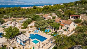 Une villa avec piscine, un espace salon extérieur et une vue sur la mer.
