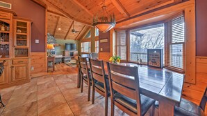 Un intérieur en bois comprenant un coin repas, une cuisine et de grandes fenêtres.