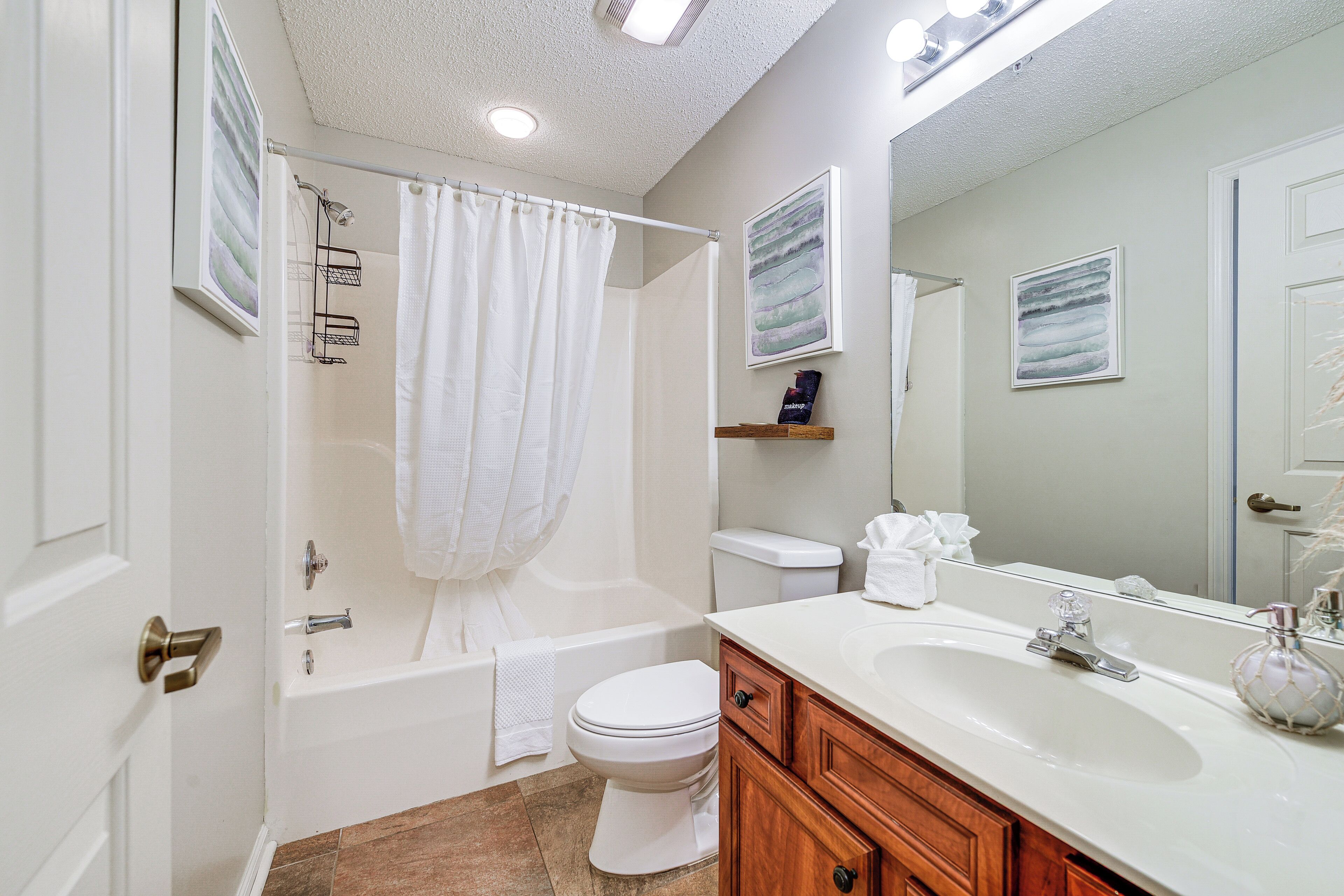 A modern bathroom with a bathtub, toilet, and sink.