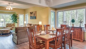 A dining area with a wooden table and chairs, a sofa, and a lamp. - Golf Course Home w/ Balcony in North Myrtle Beach! (North Myrtle Beach)