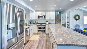A modern kitchen with stainless steel appliances, white cabinetry, and a marble countertop. - Lakeside Lacey Gem w/ Fire Pit + Private Dock (Lacey)