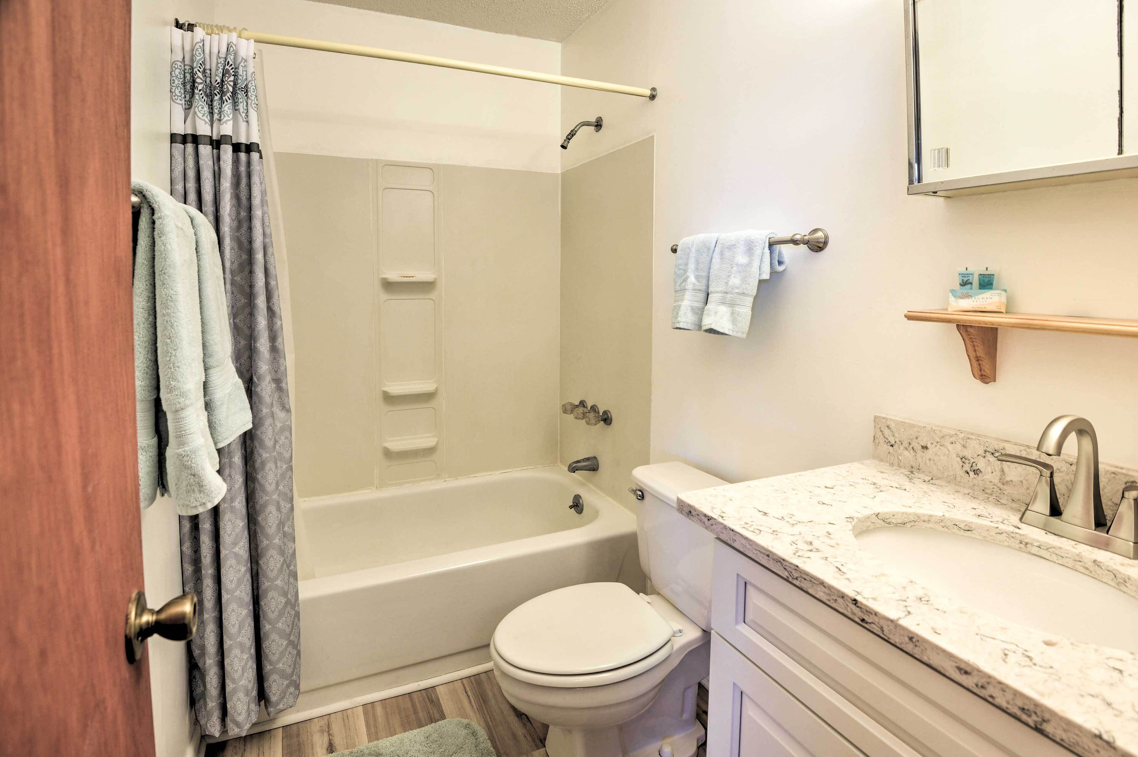 A bathroom with a bathtub, toilet, and sink.