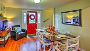A dining area with a red door, a chandelier, and a dining table set for four. - Peacock Hill Retreat on 1 Acre, 1 Mi to Harbor (Gig Harbor)