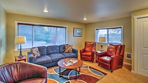 A living room with a sofa, two leather chairs, a coffee table, and two windows with blinds. - Peacock Hill Retreat on 1 Acre, 1 Mi to Harbor (Gig Harbor)