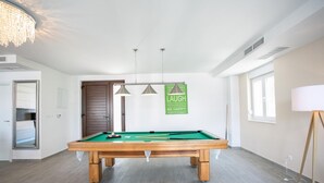 A pool table in a room with a large mirror, a door, and a green sign on the wall. - Stunning Villa Avalon for 9 Pool 2 Mins to Beach (Okrug)