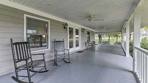A covered porch with rocking chairs, a ceiling fan, and a view of the yard. - Remodeled Pittsboro Farmhouse Sitting on 220 Acres (Pittsboro)