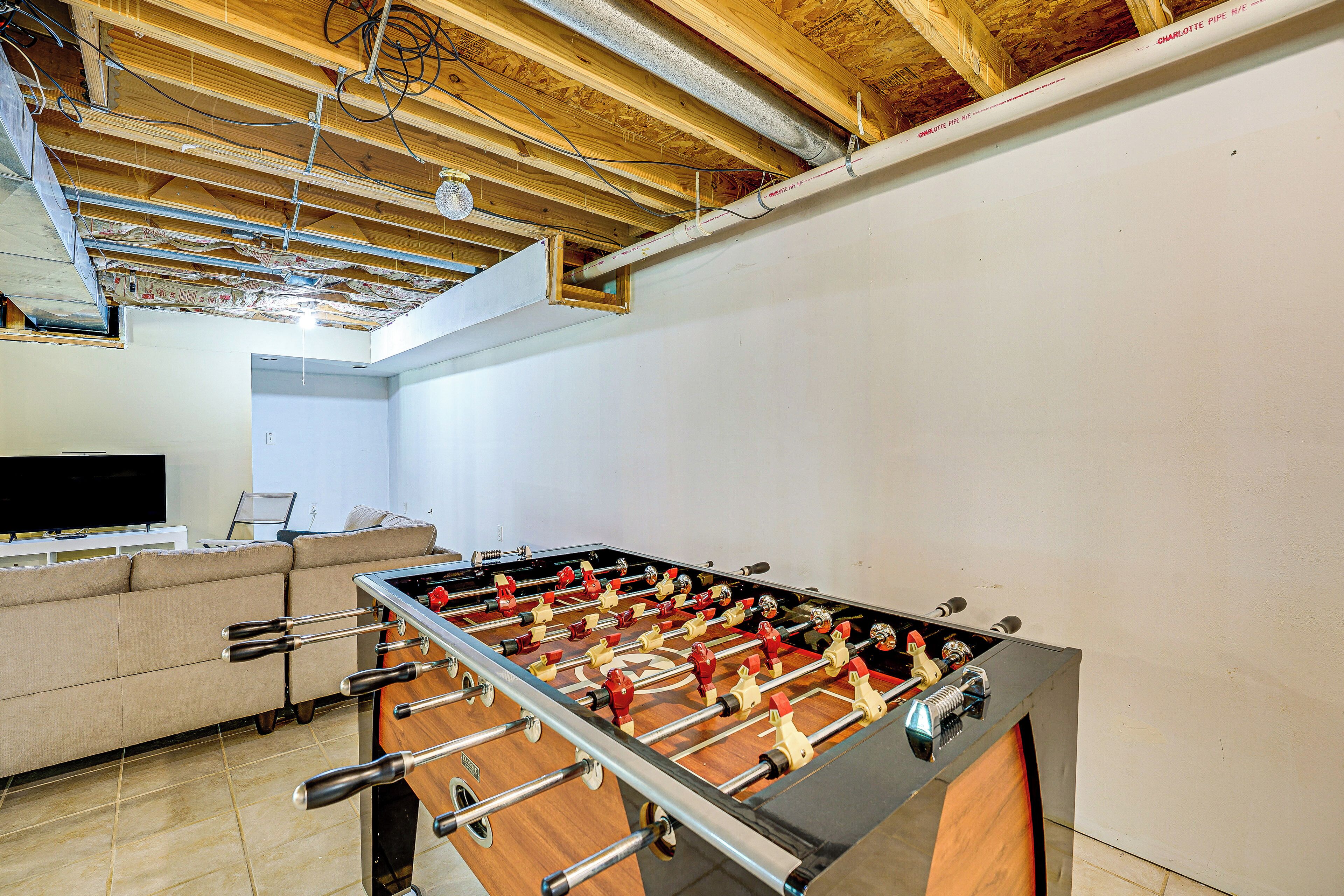 A foosball table in a room with a wooden ceiling and white walls.