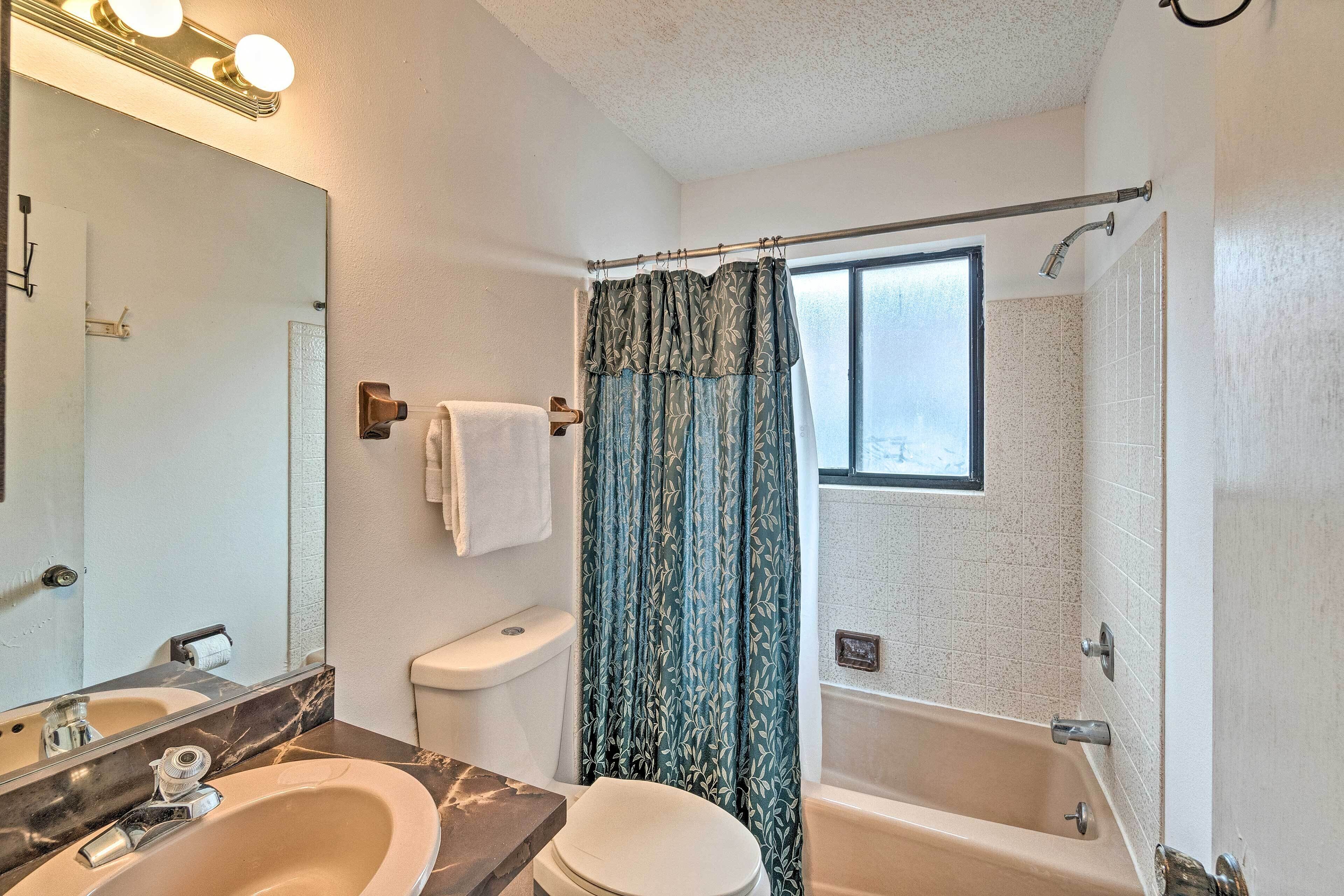 A bathroom with a sink, toilet, and bathtub.