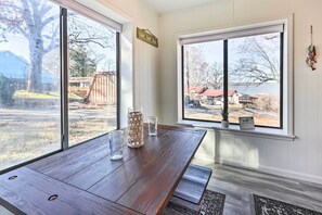 A wooden dining table with a view of a backyard and a lake. - Lakefront Retreat Hot Tub, Pool & Boat Dock (Grove)