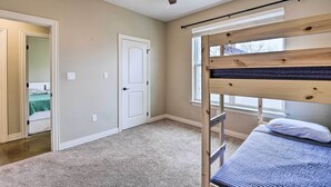 Una camera da letto con un letto a castello, una ventola a soffitto, una porta e una finestra.