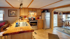 Una cocina con armarios de madera, electrodomésticos de acero inoxidable y una isla de madera.