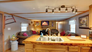 Cocina compacta con mostrador de madera, un lavamanos y una zona de comedor.