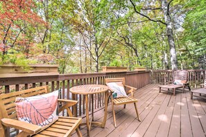 A wooden deck with outdoor seating and a view of a forest. - Chic Brevard Cabin - Nature, Trails, & Water! (Brevard)