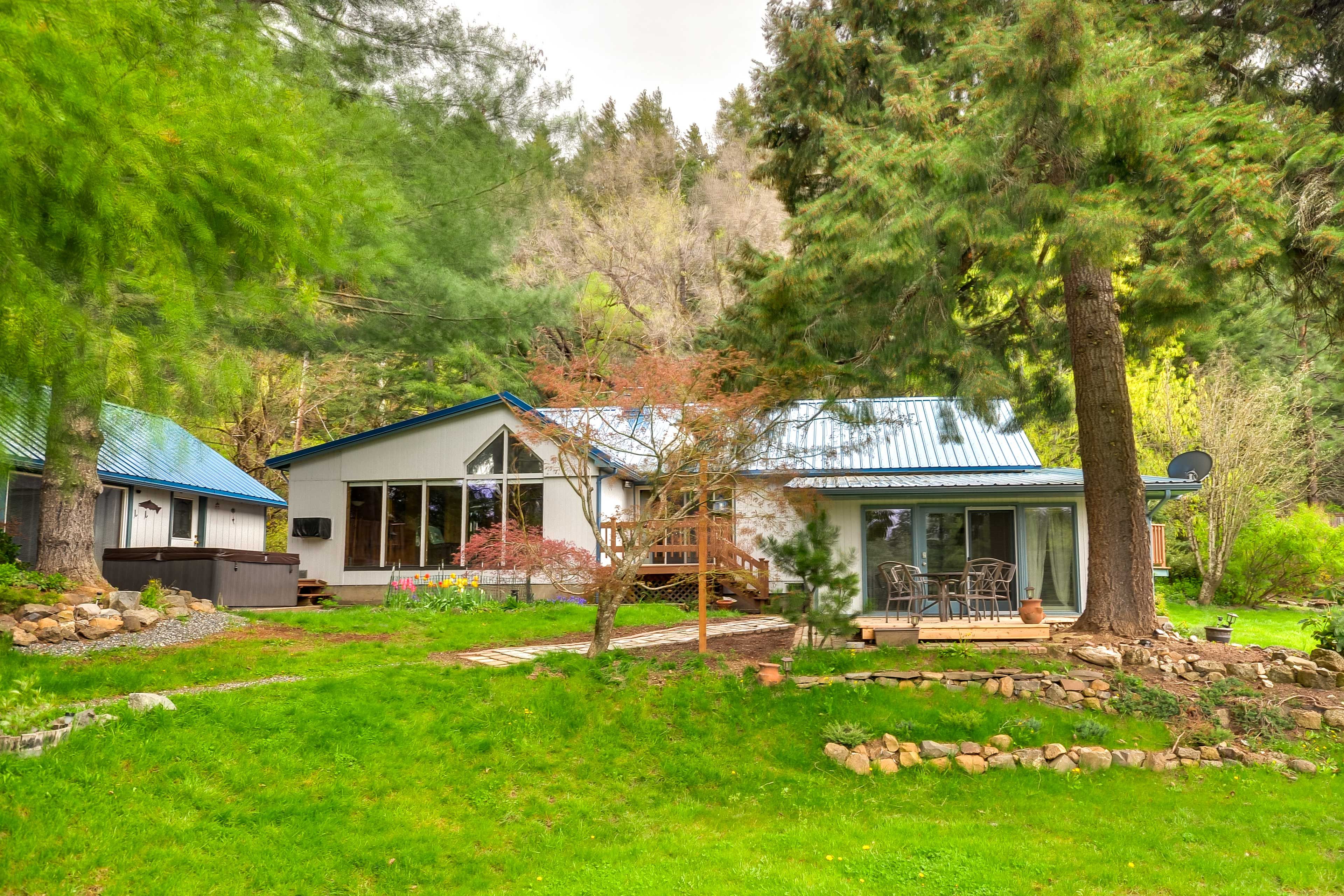A cabin with a blue roof, surrounded by lush greenery and trees.