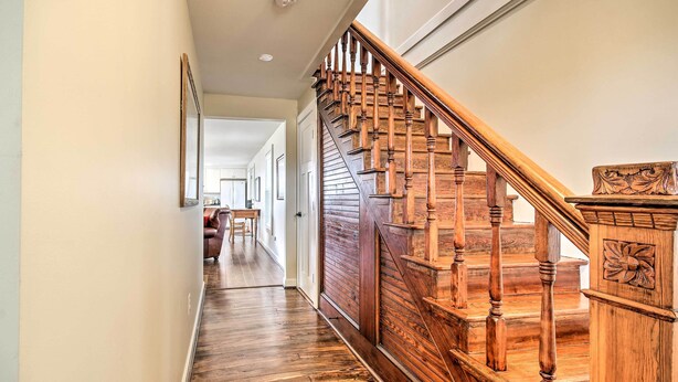 A wooden staircase with a handrail and a decorative panel on the right side.