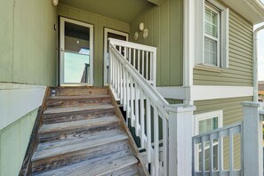 A wooden staircase with white railings leading to a green door. - Cozy Carolina Beach Condo w/ Ocean Views! (Carolina Beach)