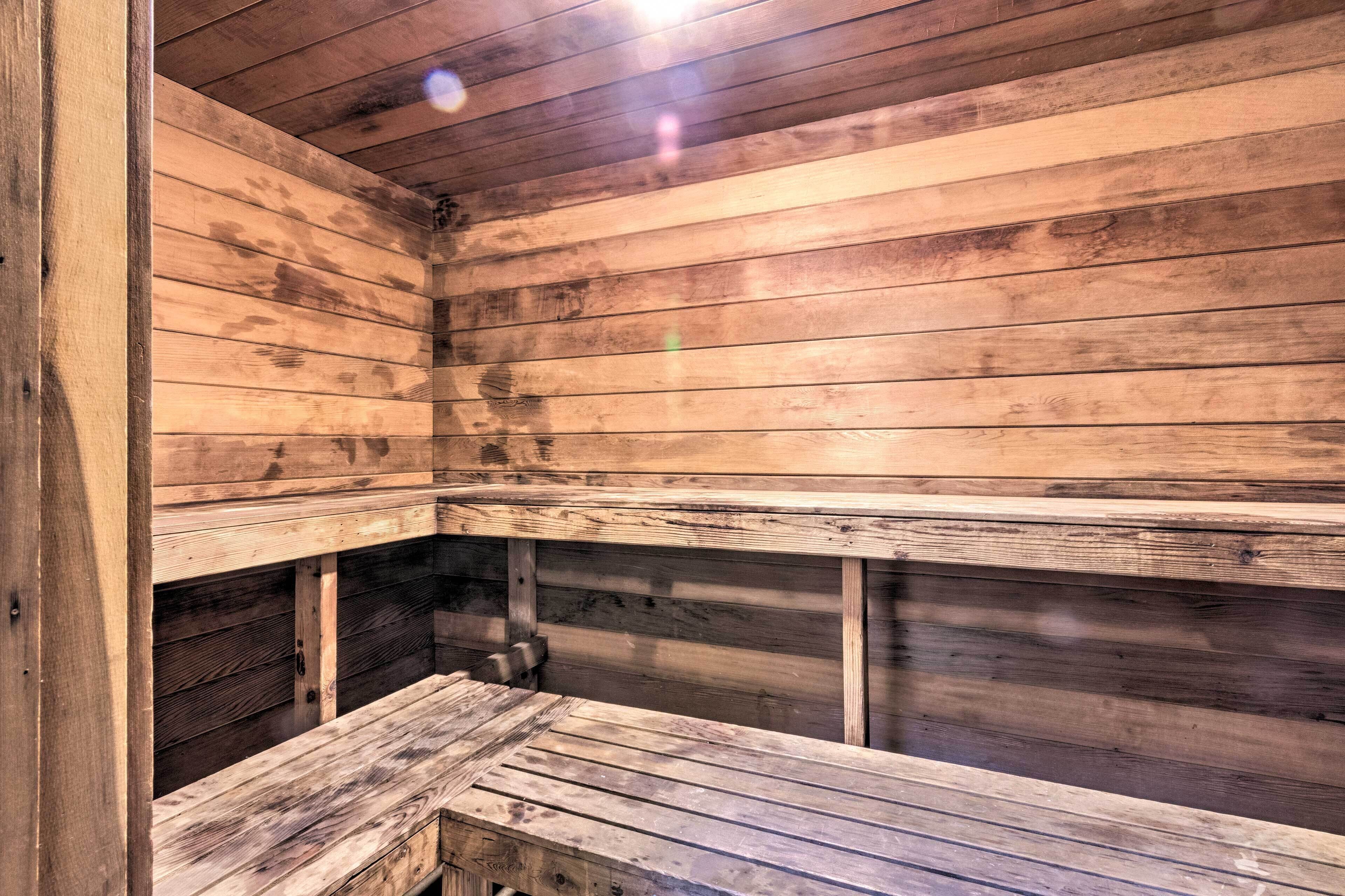 A wooden sauna with benches and a bench in the foreground.