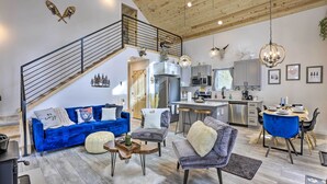 A spacious living area with a blue sofa, grey armchairs, a wooden coffee table, and a staircase leading to an upper level. - 1 Mi to St Marys Glacier Trail: Modern Mtn Cabin! (Idaho Springs)