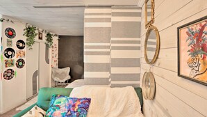 A cozy room with a green sofa, a striped wall divider, and a framed tiger painting. - 'the Goat Hut' Studio Casita: 11 Mi to Strip! (Las Vegas)