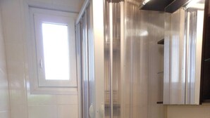 A compact bathroom with a shower enclosure, a sink, and a toilet. - APT 2 ROOMS 27m2 + TERRACE 22m2 REF 4015 (MARSEILLAN PLAGE)