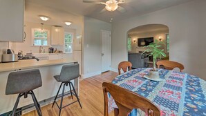 A modern kitchen with a central island, bar stools, and a dining table with a patterned tablecloth. - Charming Cincinnati Home < 10 Mi to Downtown! (Cincinnati)