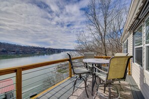 A deck with a table and chairs overlooking a river. - Gravois Mills Home: Boating Vacation! (Gravois Mills)