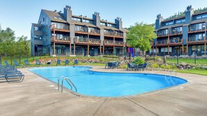 A modern building with a swimming pool, outdoor seating, and a playground. - Lutsen Mountain Townhome - 2 Mi to Lake Superior! (Lutsen)