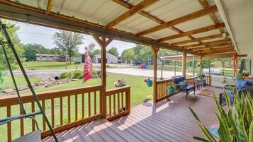 Enjoy al fresco dining on this outdoor deck with comfortable seating and lush green surroundings.