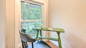 Ein Eckzimmer mit Fenster, einem Sessel und einem kleinen Tisch.