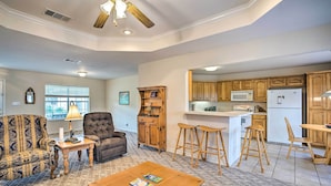 A spacious living room with a large wooden coffee table, a tufted sofa, and a fireplace. - Family Alba Home w/ Boat Dock on Lake Fork! (Alba)