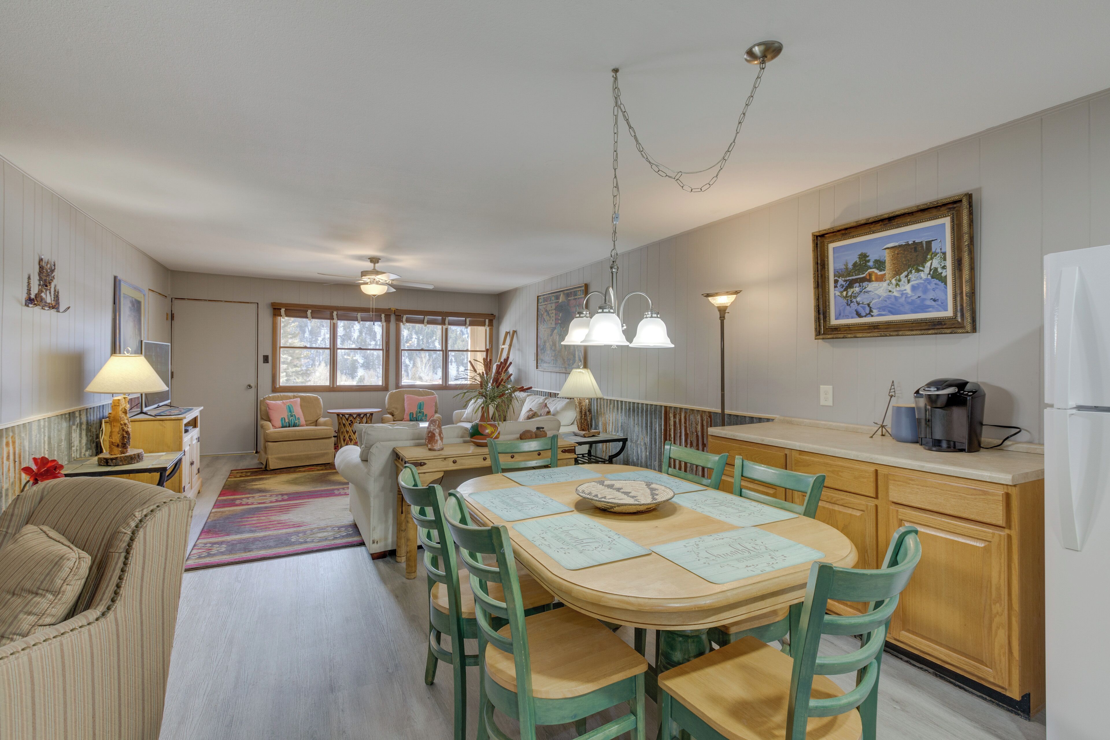 A cozy kitchen with a dining table, chairs, and a refrigerator.
