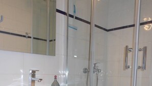 A modern bathroom with a glass shower enclosure, a wooden vanity, and a large mirror. - VILLA  3 ROOMS MEZ 41m2 + TERRACE 12m2 REF 4027 (MARSEILLAN PLAGE)