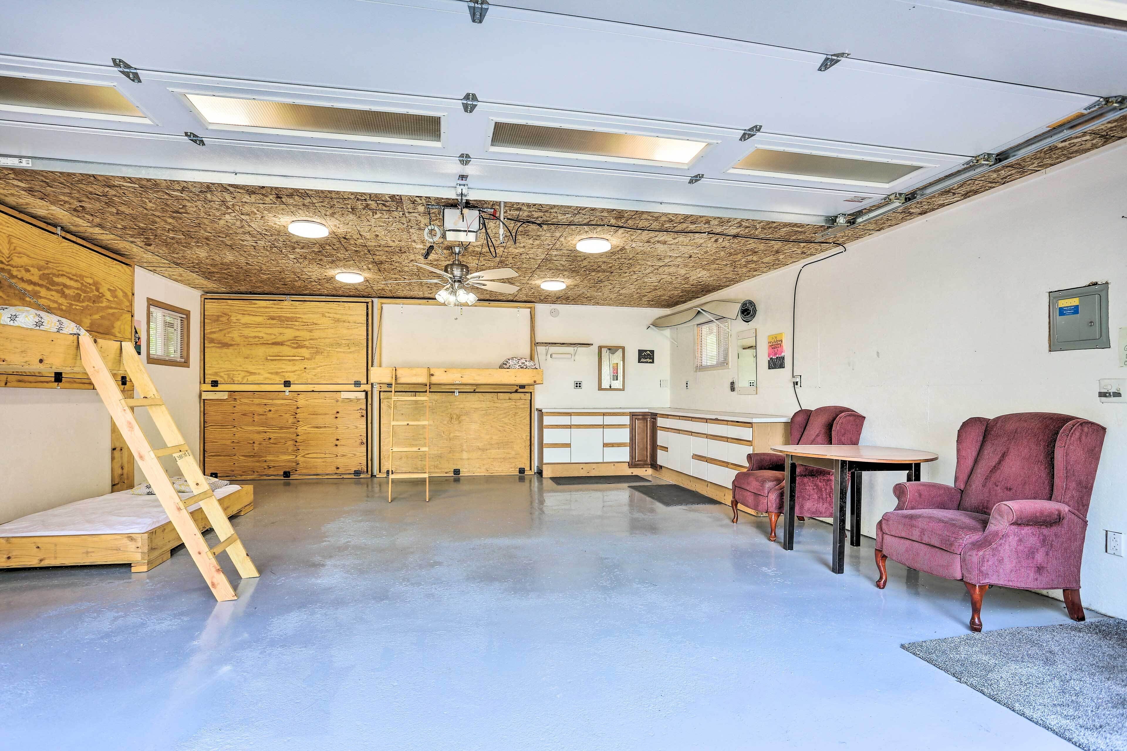 A spacious room with a wooden ceiling, a ceiling fan, and a wooden ladder.