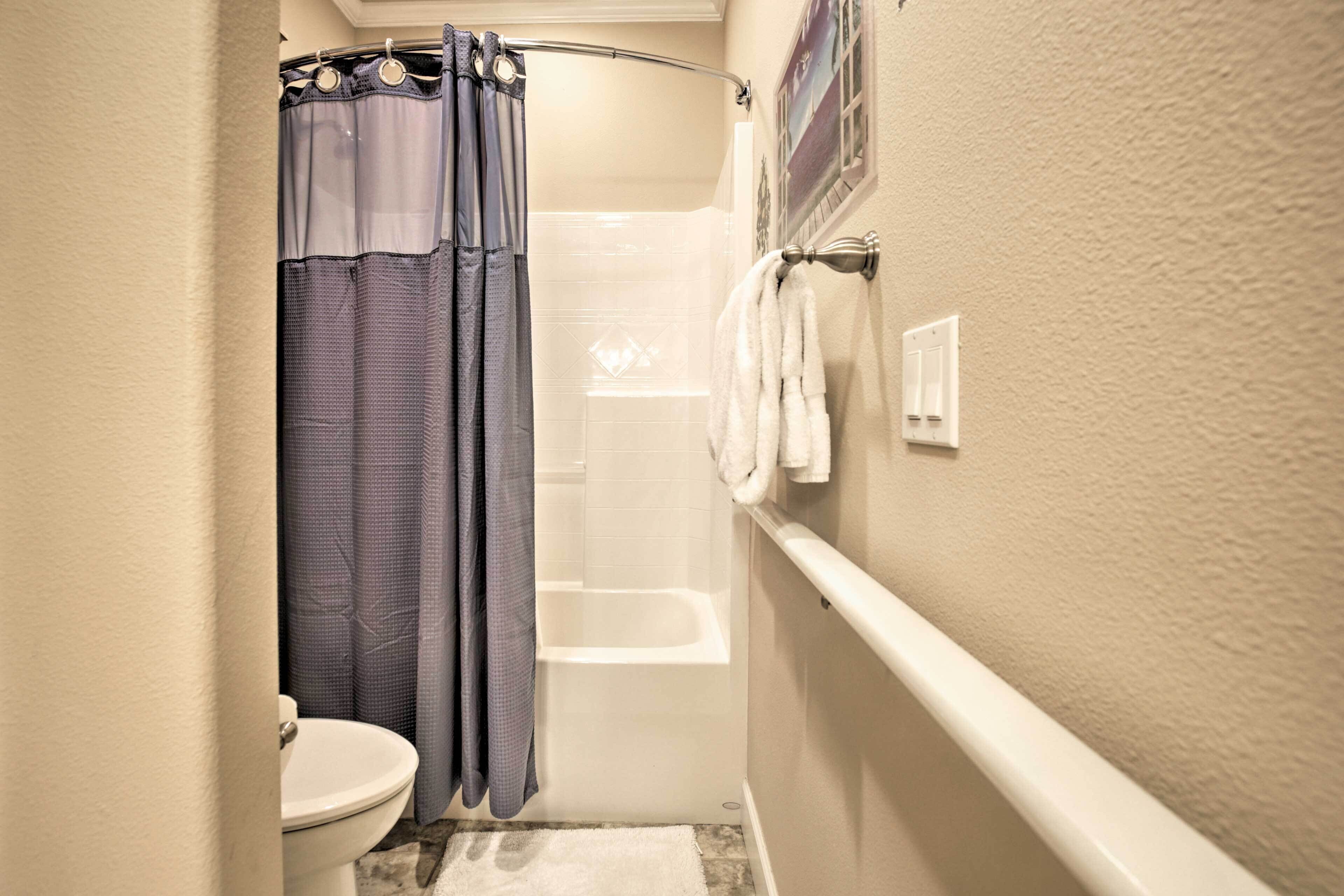 A bathroom with a shower, toilet, and bathtub.
