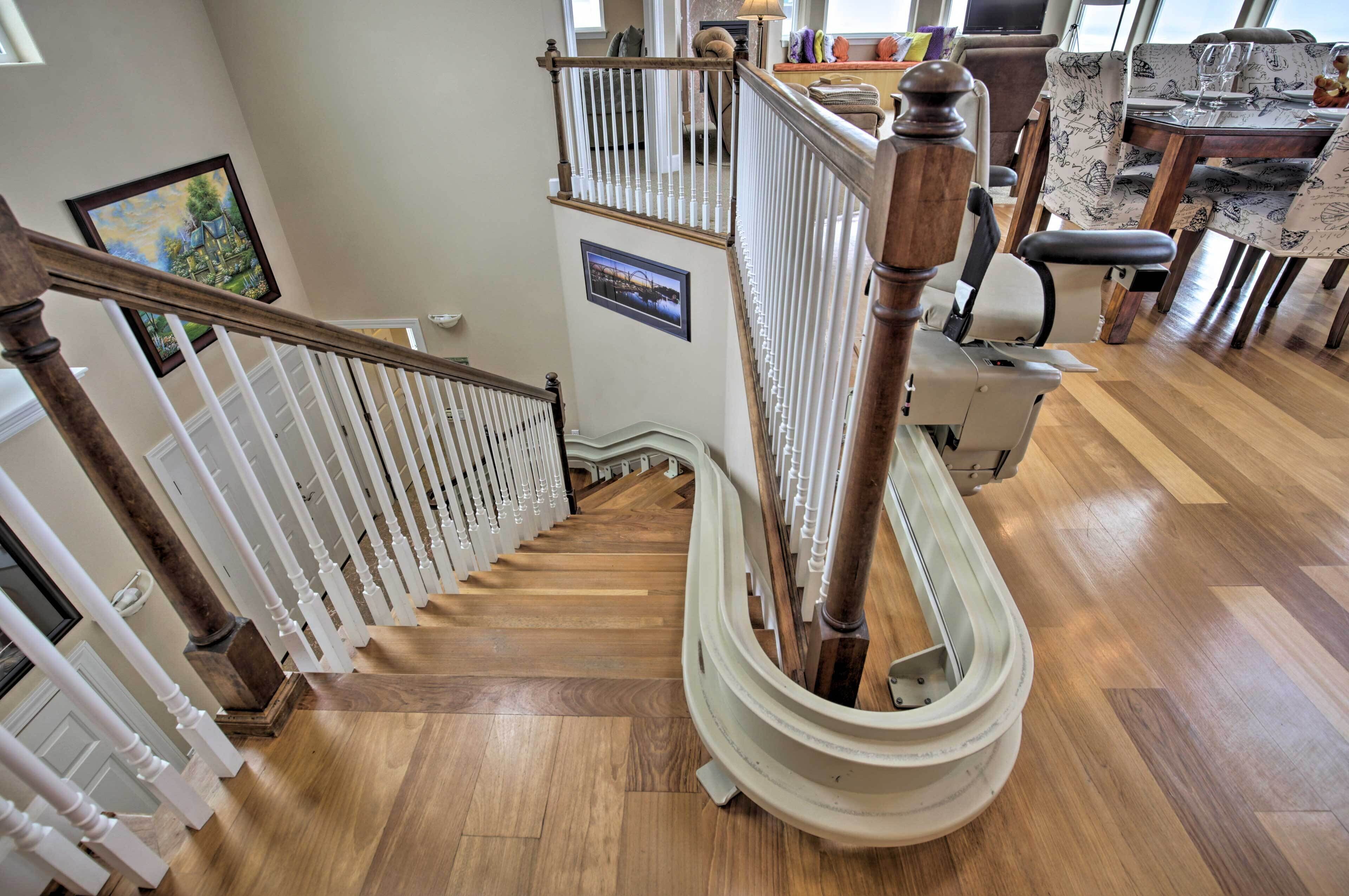 Una escalera de madera con balaustres blancos que conduce a un segundo piso.