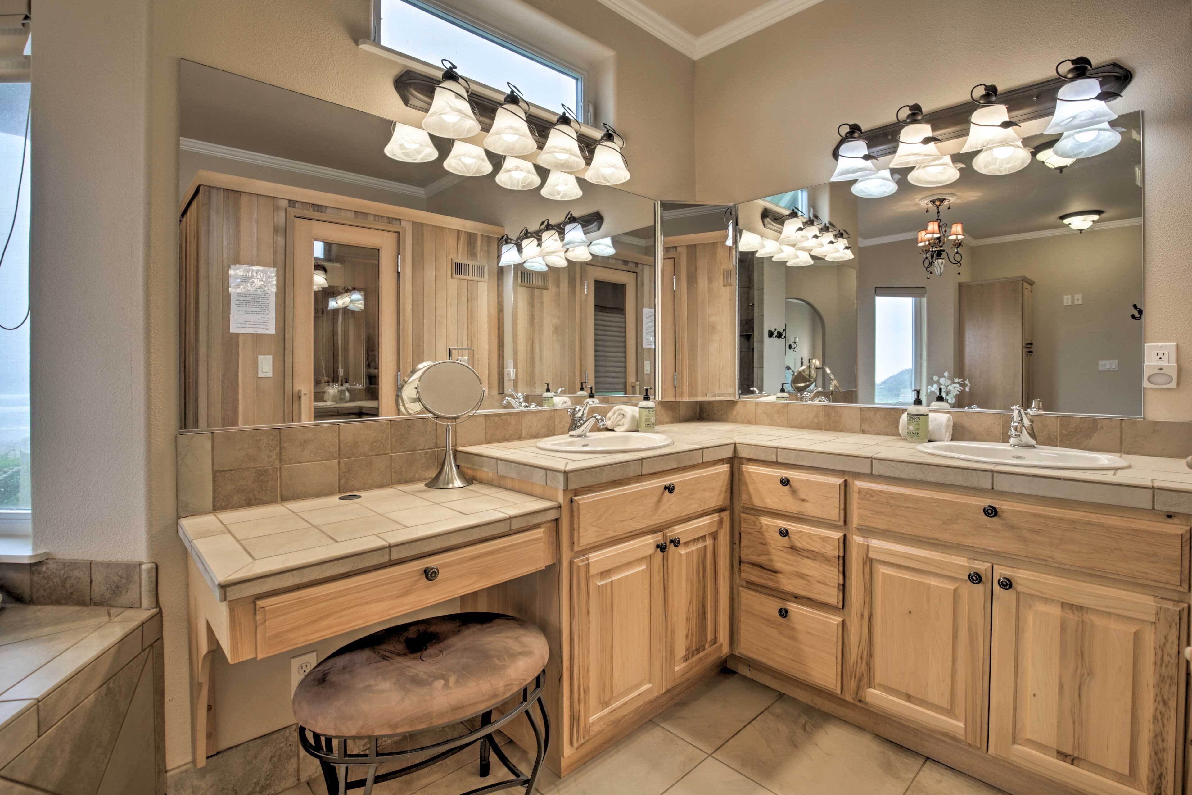 A modern bathroom with wooden cabinets, a vanity with a mirror, and a large mirror above the sink.
