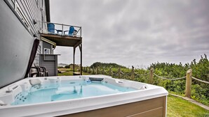 A hot tub with a wooden deck and a small balcony with blue chairs. - Oceanfront South Beach Home w/ Hot Tub & Sauna (South Beach)