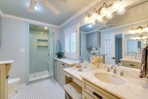 A modern bathroom with a large mirror, vanity, and shower. - Decks & Lake Views: Waterfront Hot Springs Home! (Hot Springs)