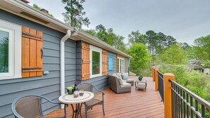 A wooden deck with outdoor furniture, including a table and chairs, and a sofa. - Decks & Lake Views: Waterfront Hot Springs Home! (Hot Springs)