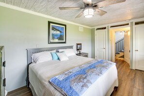 A bedroom with a bed, a ceiling fan, a framed picture on the wall, and a staircase leading to another room. - Decks & Lake Views: Waterfront Hot Springs Home! (Hot Springs)