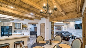 A spacious kitchen with wooden beams, a dining area with a round table, and a living room with a leather sofa. - Las Cruces Home 'La Casa Blanca' w/ Courtyard (Las Cruces)