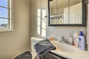 A bathroom with a white sink, a mirror, a towel, and toiletries. - Castro Valley Home w/ Bay Area Views! (Castro Valley)