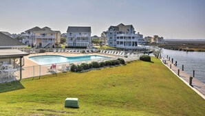 A residential area with a swimming pool, a grassy lawn, and a waterfront view. - Manteo Waterfront Resort Home w/ 30-ft Dock! (Manteo)
