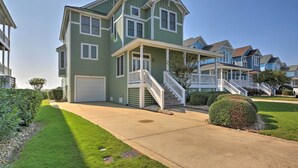 A two-story house with a front porch and a garage. - Manteo Waterfront Resort Home w/ 30-ft Dock! (Manteo)
