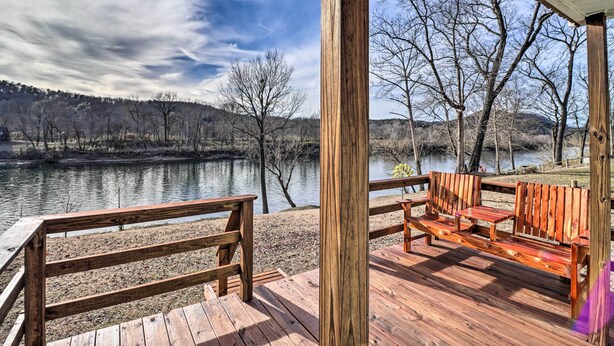 A wooden deck with a bench overlooking a calm river, surrounded by bare trees and hills. - La Petite Maison in Mount Olive w/ Fire Pit! (Mountain View)