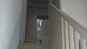 A staircase with a handrail, leading to a door with a window above it. - VILLA  3 ROOMS MEZ 48m2 + TERRACE 7m2 REF 4034 (MARSEILLAN PLAGE)